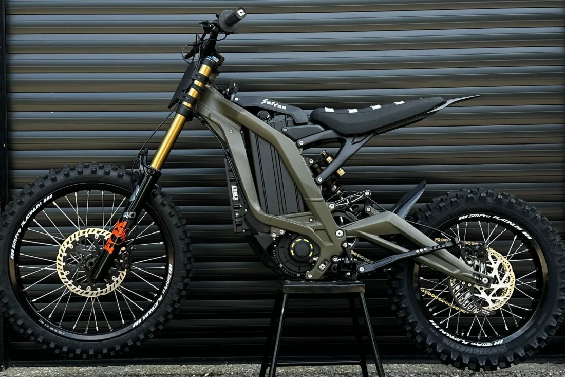 Side view of a Sur-Ron Light Bee showing the handlebars, forks, wheels, brakes, battery, motor, seat and mudguards